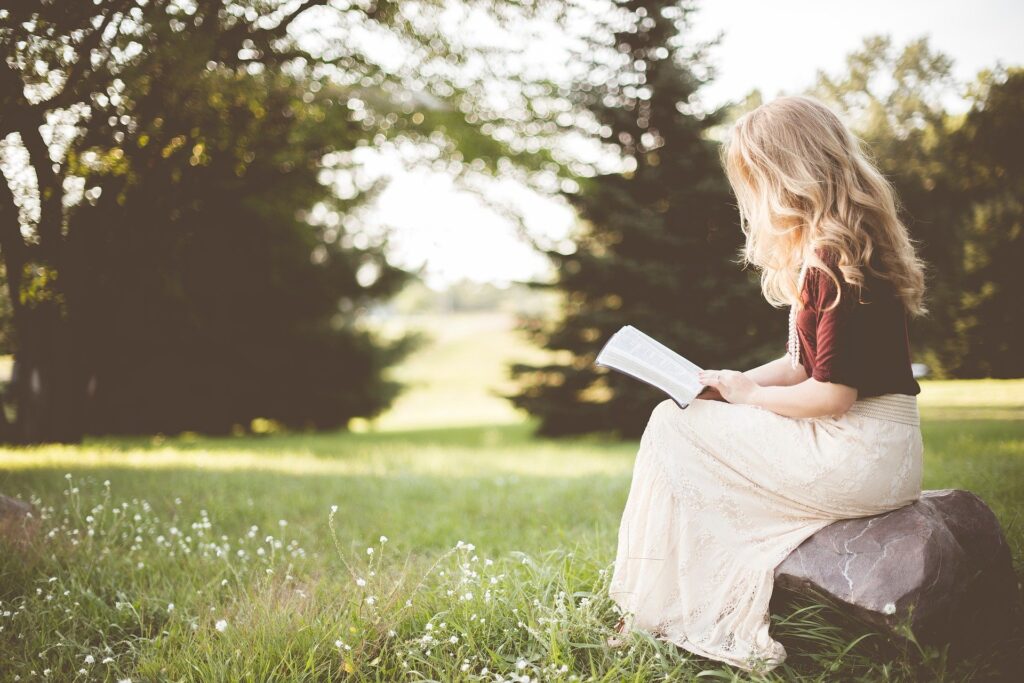 woman sitting in a park reading