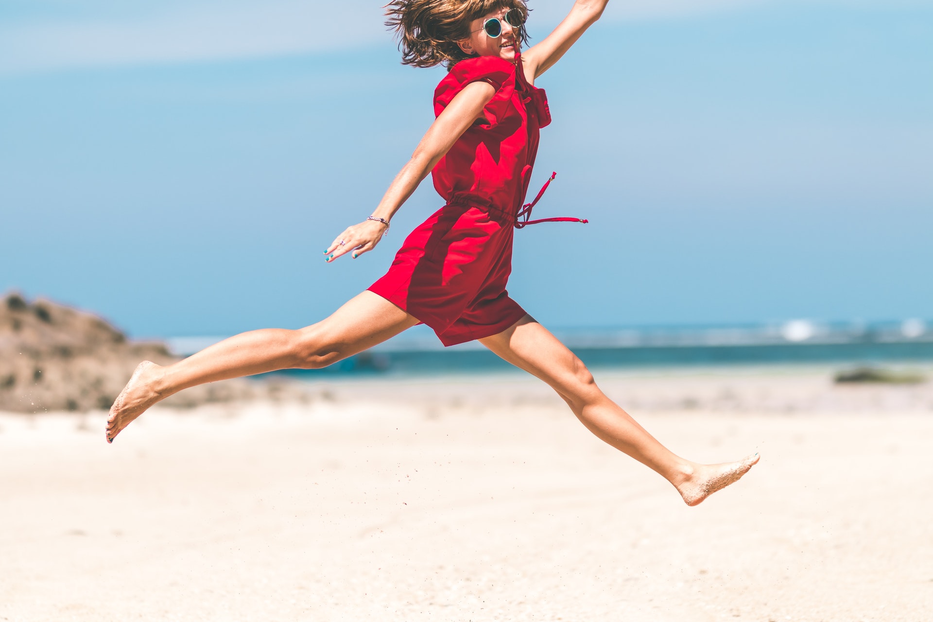 woman in red dress happy jumped in the air