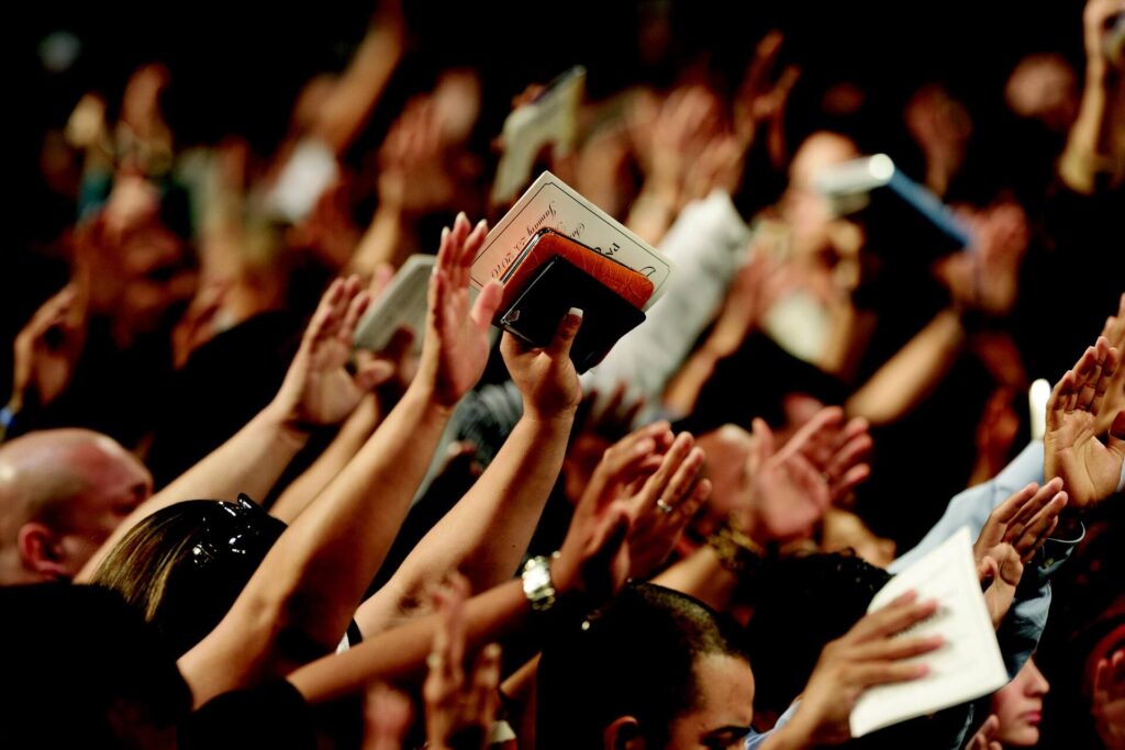 people in church lifting hand and bible